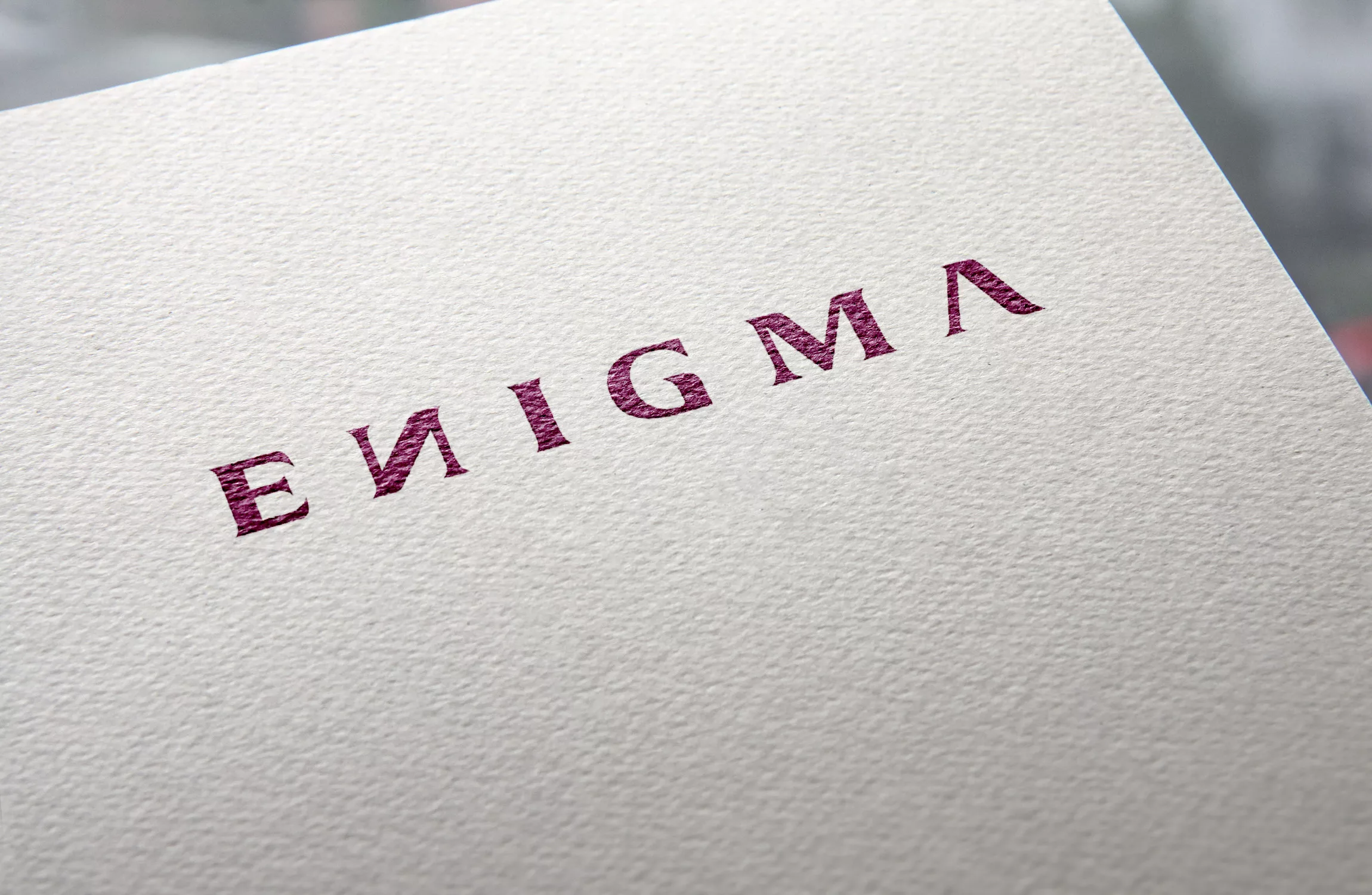 Logo ENIGMA embossé sur papier – texture premium