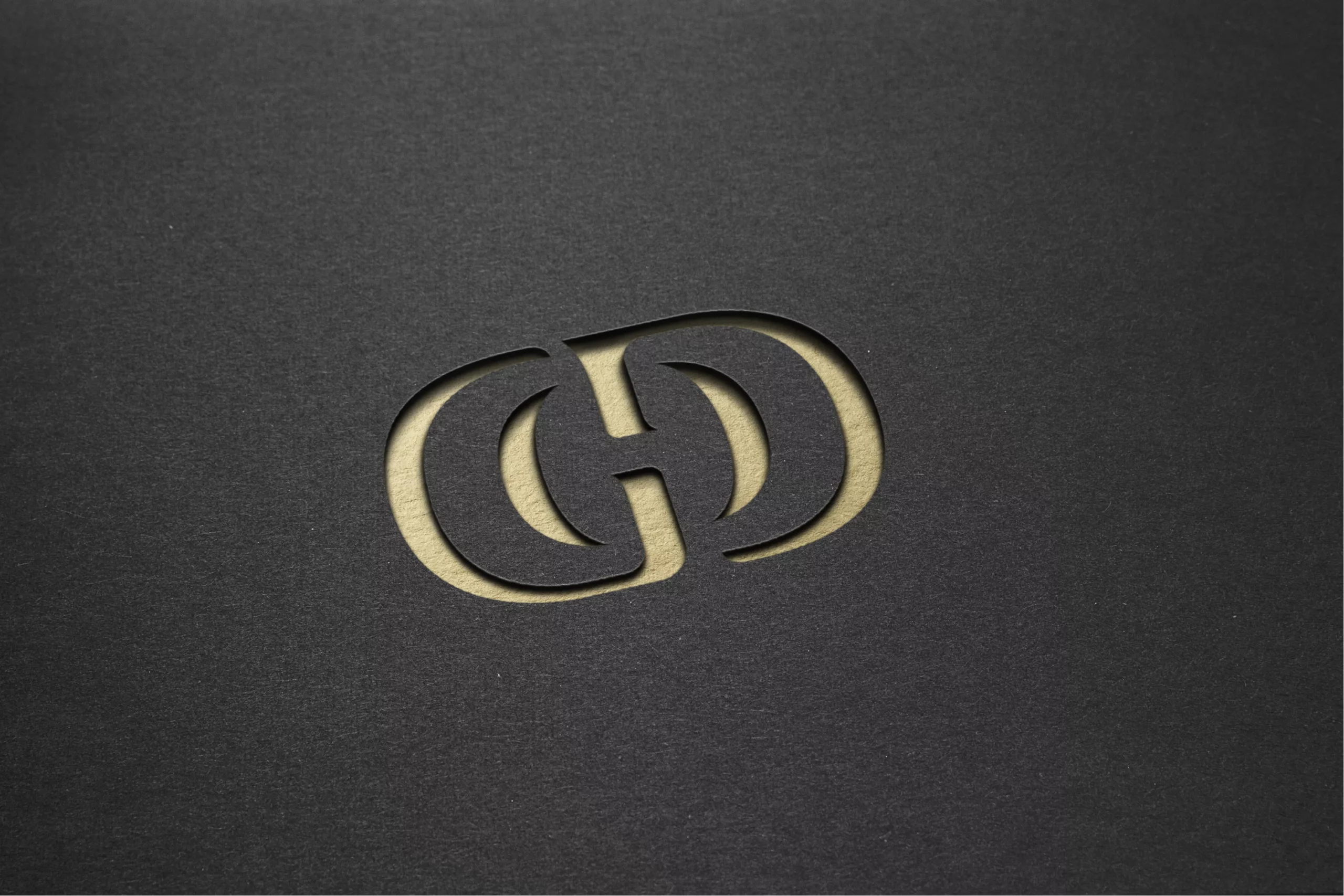 Logo LE GRAND DETOUR embossé doré sur papier noir – texture premium